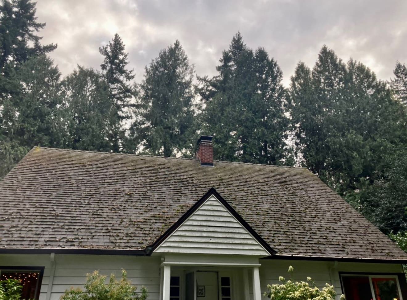 Two-story Vancouver, WA home with a moss-covered roof before professional roof cleaning
